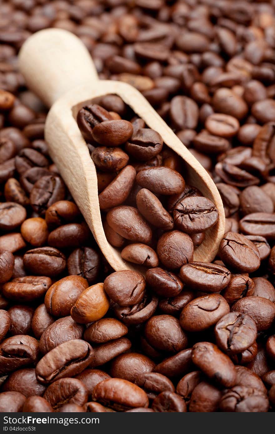 Coffee beans and wooden scoop close up