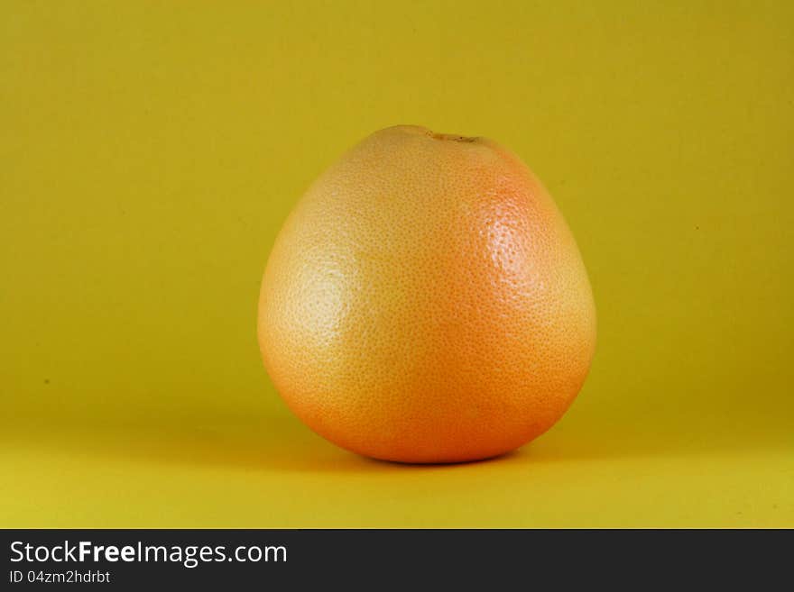 A fresh orange on yellow background