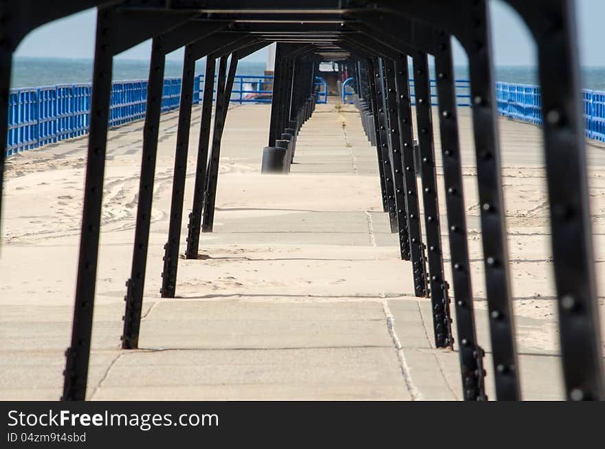 A metal bridge leading out to the north pier light house in St Joe Michigan, creates an interesting tunnel effect. A metal bridge leading out to the north pier light house in St Joe Michigan, creates an interesting tunnel effect