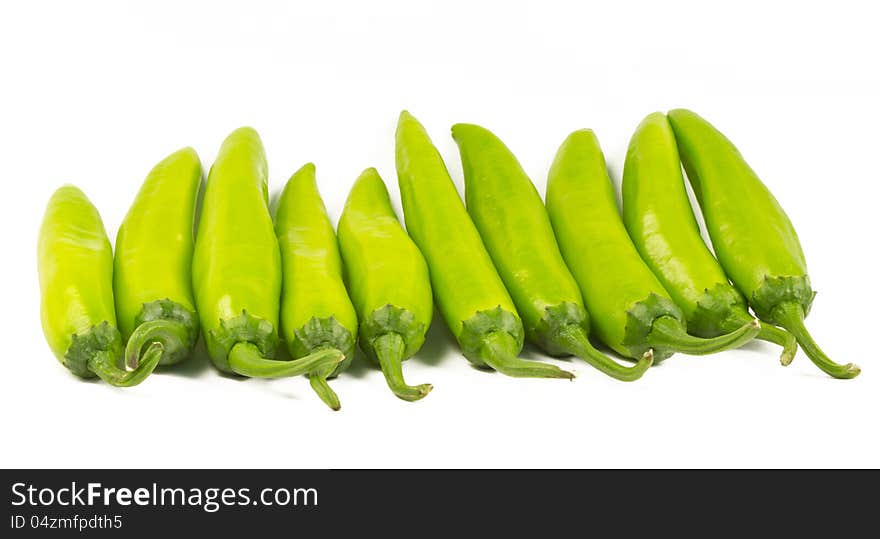 Green chillies (Jalapenos) arranged in a row on white background. Green chillies (Jalapenos) arranged in a row on white background.