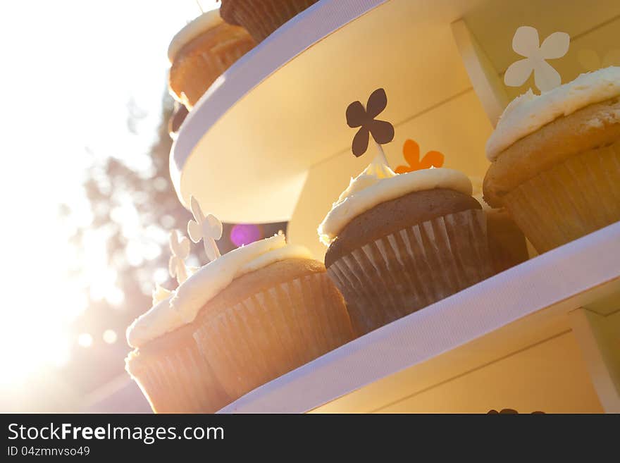 Three types of wedding cupcakes at a dessert recepition outdoors.