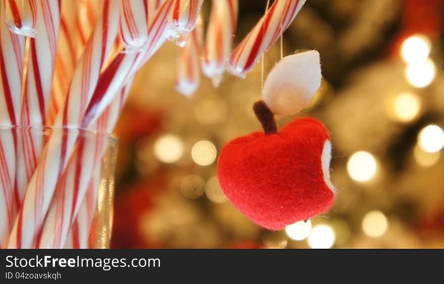 Handmade red apple with bite on a bunch of christmas candy cane. Handmade red apple with bite on a bunch of christmas candy cane