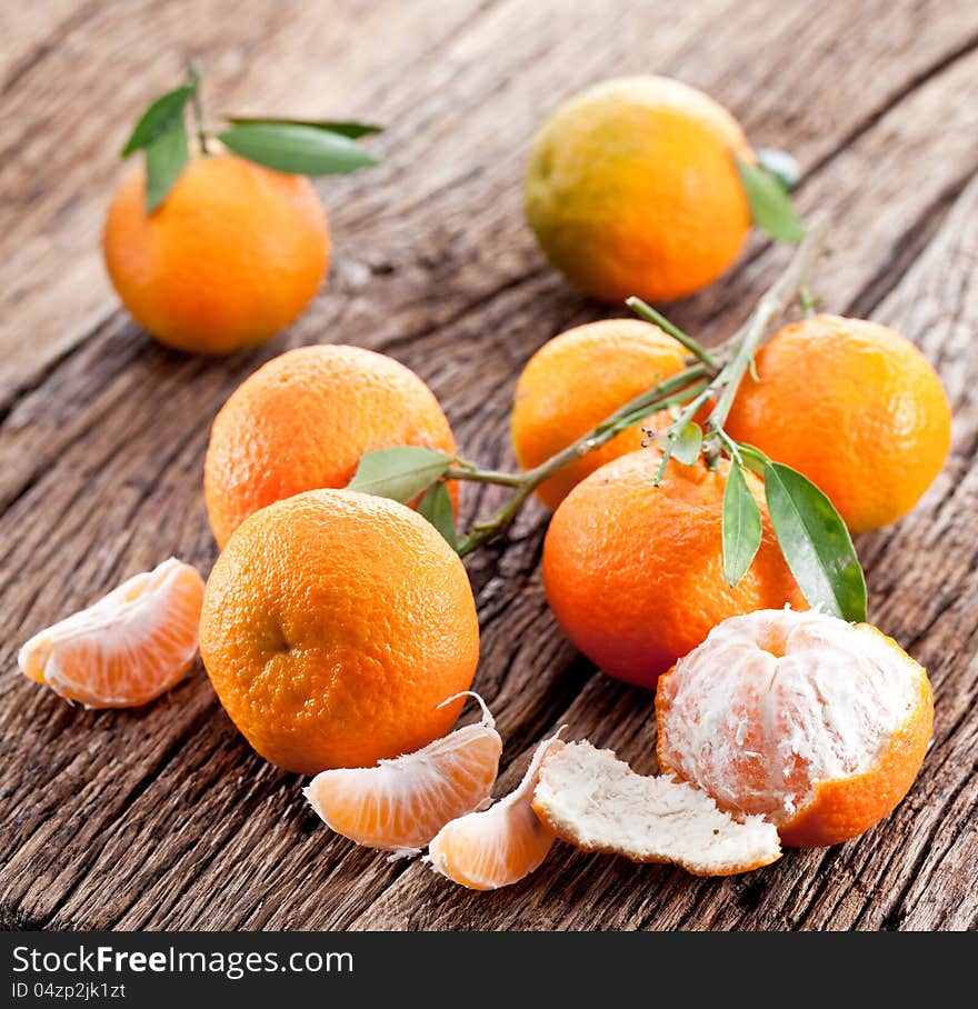 Tangerines with leaves on a wooden table. Tangerines with leaves on a wooden table.