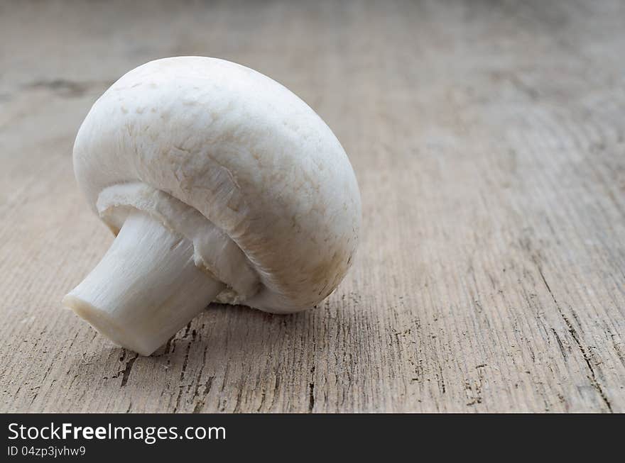 Mushroom champignon on wood texture