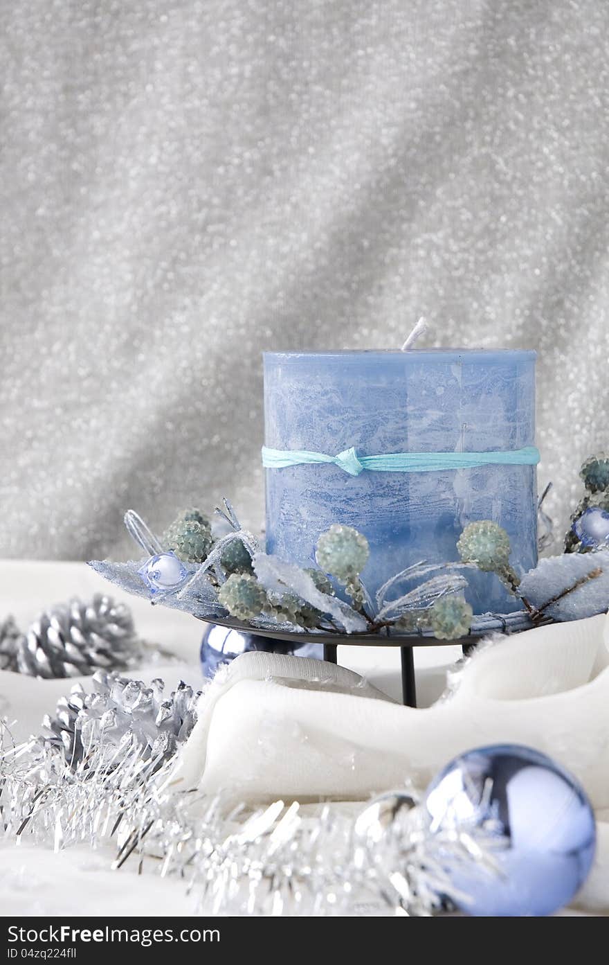 Blue candle in winter moment decorated with ornaments