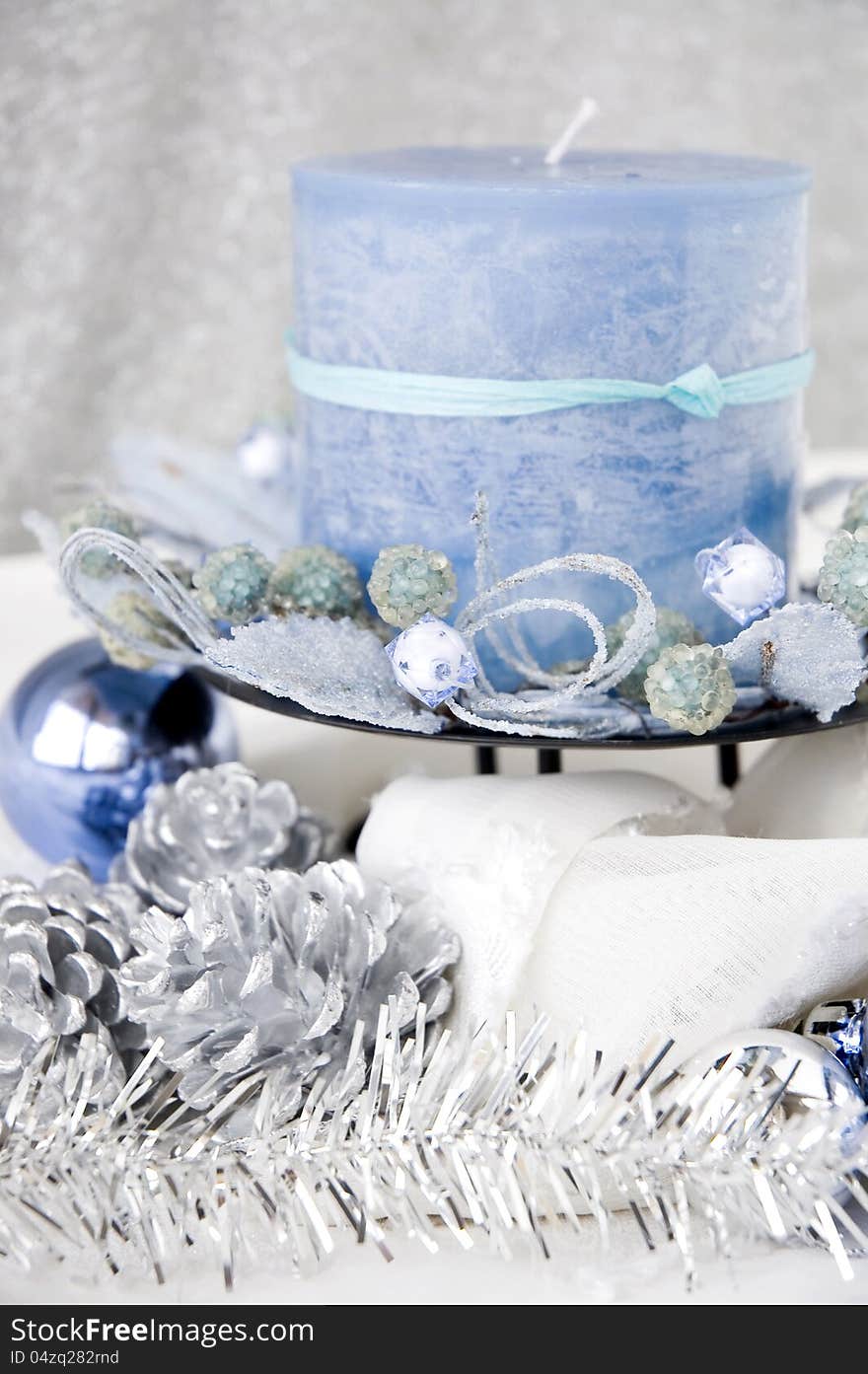 Close up blue candle decorated with christmas ornaments