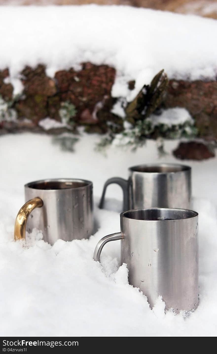 Thermos cups stand in the snow outdoors. Thermos cups stand in the snow outdoors