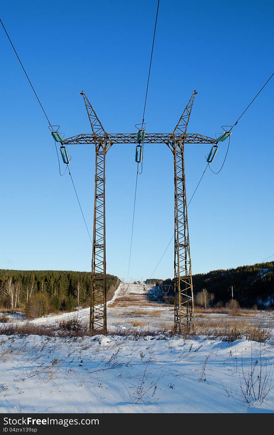 Tower of a high-voltage electric line, in a sunny day against the blue sky. Tower of a high-voltage electric line, in a sunny day against the blue sky