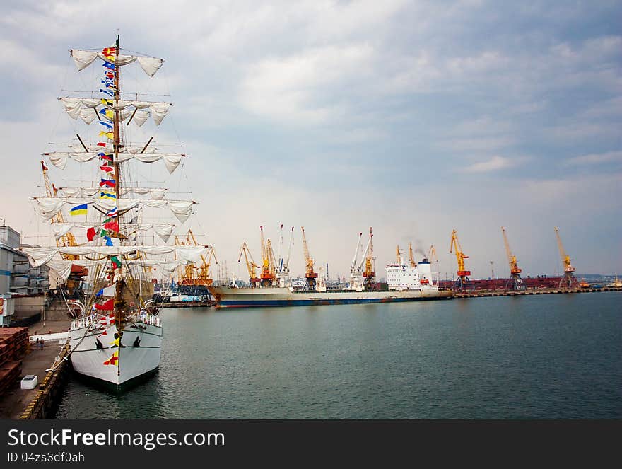 Sailing ship and a cargo ship docked in the port