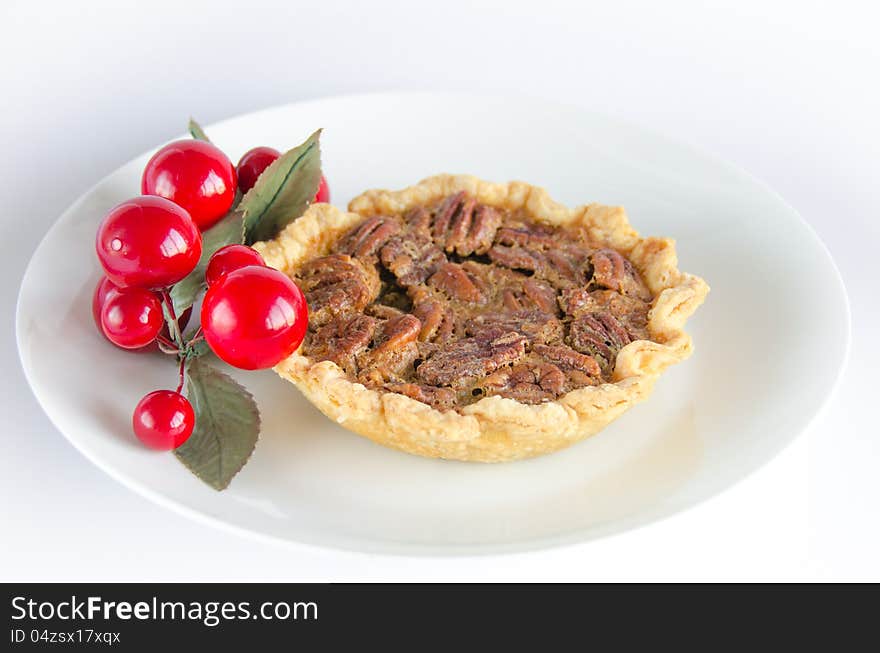 Pecan tart on white plate with decoration