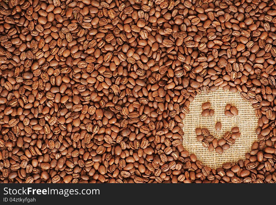 Face coffee frame made of coffee beans on burlap texture