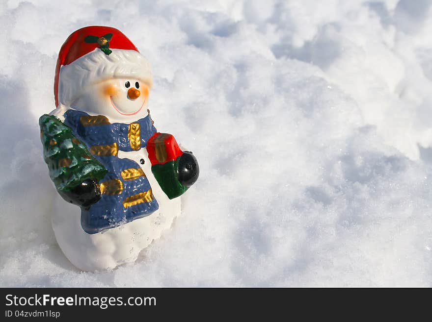 Smiling snowman figurine in snow