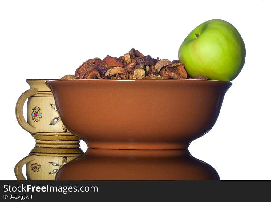 Ceramic bowl with dried apples and green apple