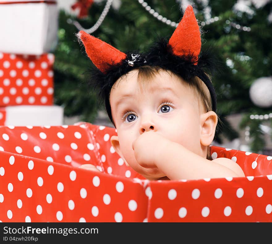 Christmas baby girl with horn in a studio. Christmas time