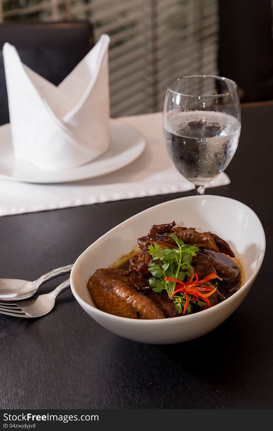 Bowl with chicken soup and chicken wings set on the table