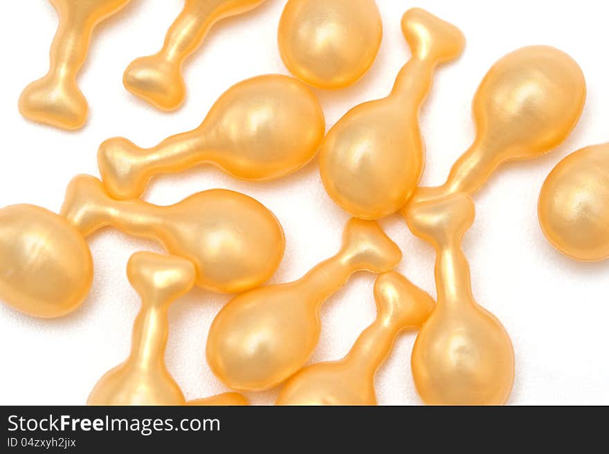 Yellow fish oil capsules on a white background