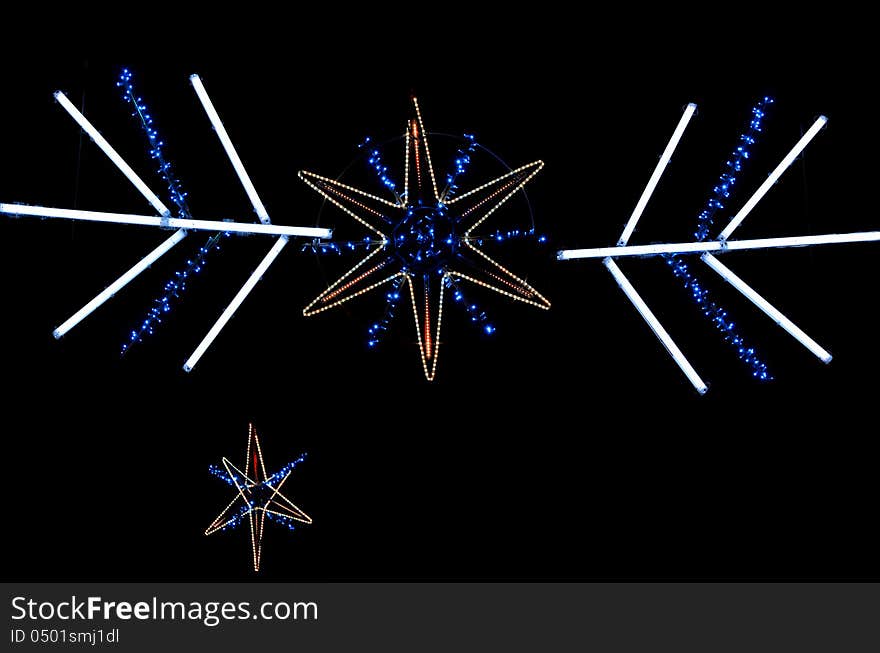 Christmas decoration with star shaped yellow and blue lights isolated on black