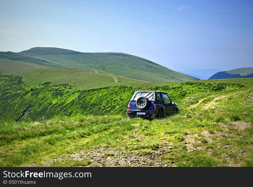 Travelling by car in a mountain pasture