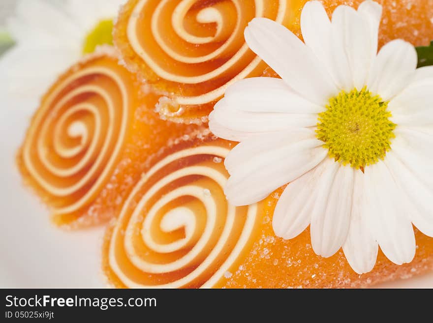 Orange candy fruit on a plate background, closeup