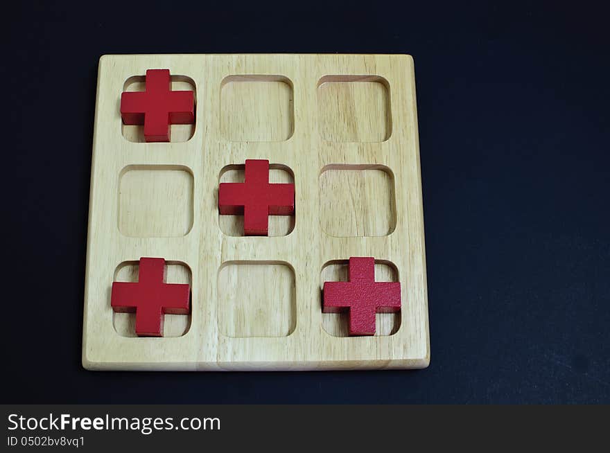 Red cross on wood board on black background