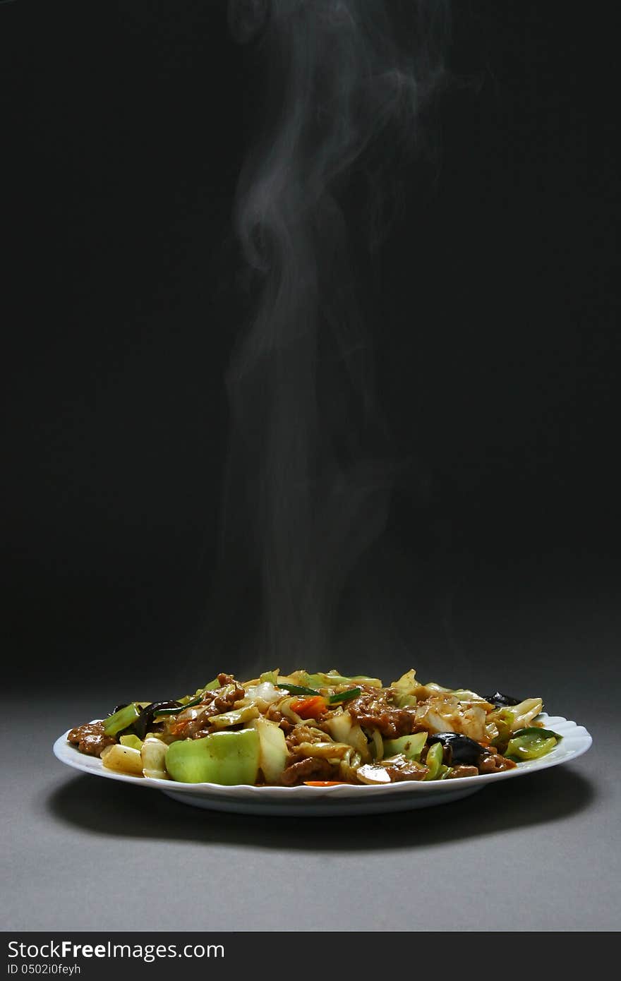 Beef with vegetables and bamboo shoots in plate on a neutral background