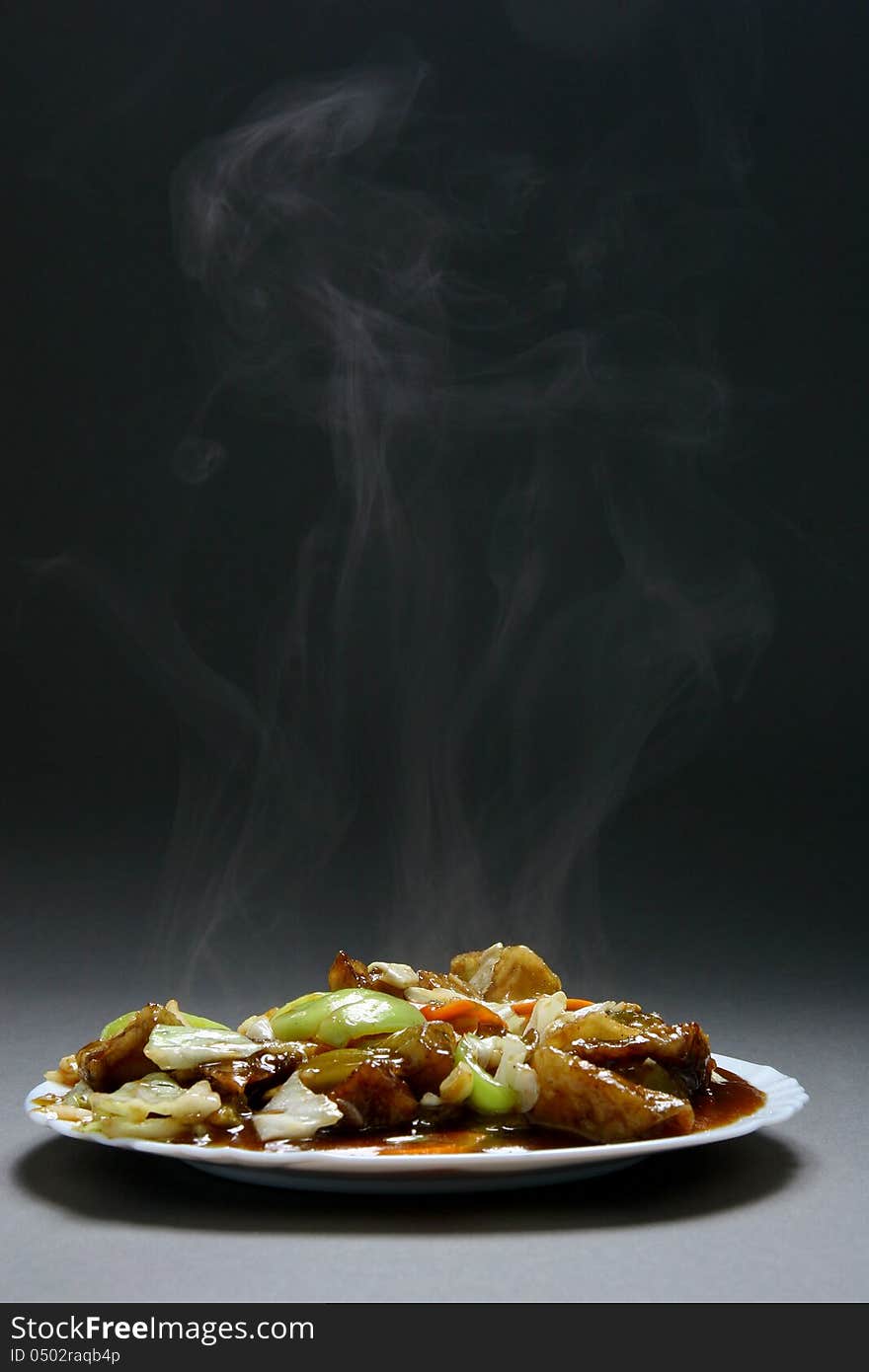 Beef with vegetables and bamboo shoots in plate on a neutral background