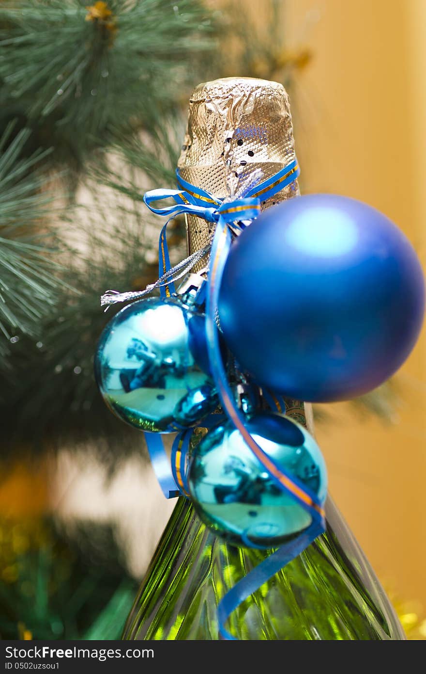 The bottle of champagne costs under a New Year tree. The bottle of champagne costs under a New Year tree