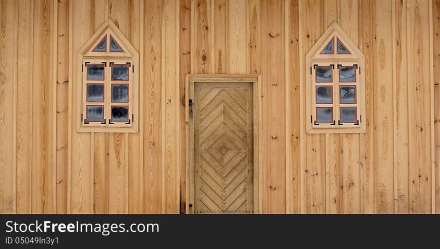 Front of wooden house with door and a pair of windows