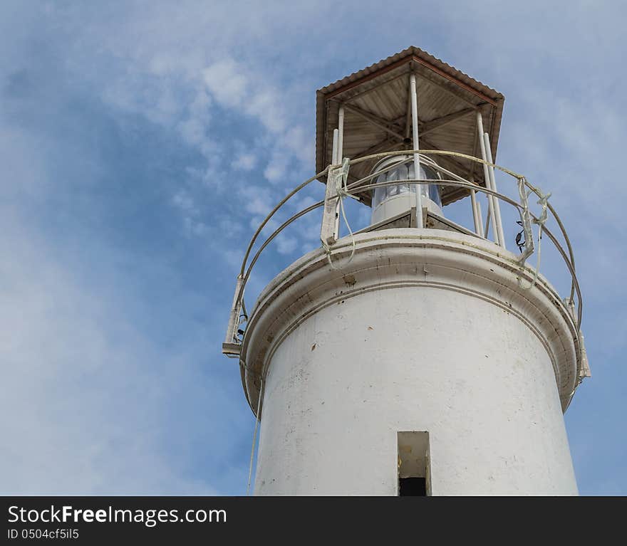 A lighthouse is stand stretch up with cloundy blue sky