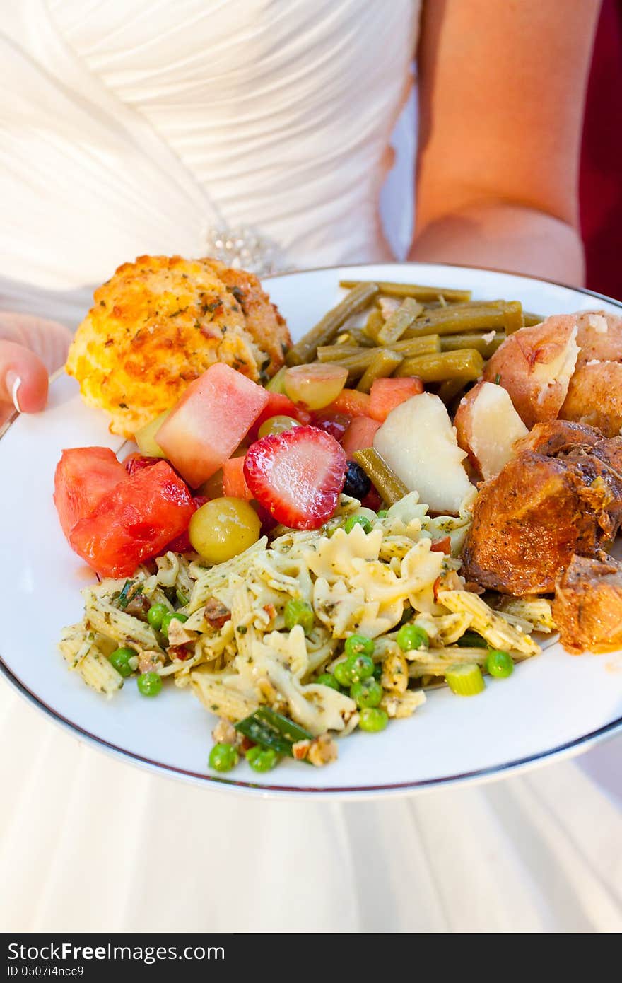 The meal of a bride on her wedding day looks healthy and cooked well with potatoes, fruit, pasta salad, green beans, chicken and more. The meal of a bride on her wedding day looks healthy and cooked well with potatoes, fruit, pasta salad, green beans, chicken and more.