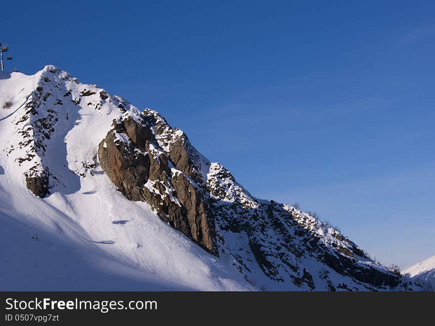 Bright winter day in Caucasian mountains with one slope shown. Bright winter day in Caucasian mountains with one slope shown