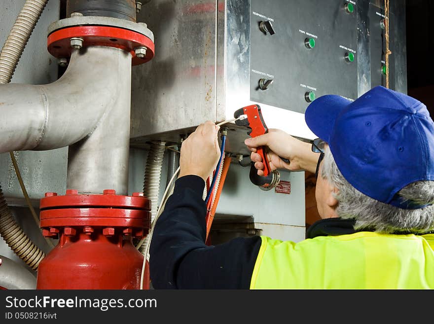 Electrician while working with cables and wires of electronic components