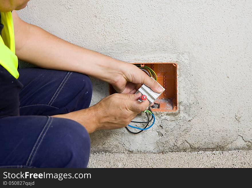 Electrician while working with cables and wires of electronic components