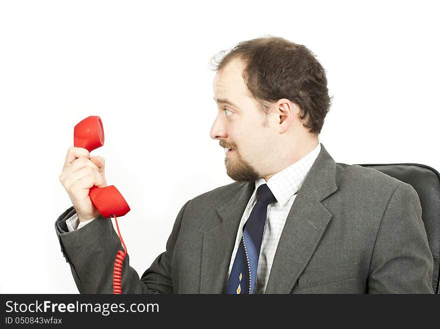 Businessman with red phone looks surprised. Businessman with red phone looks surprised