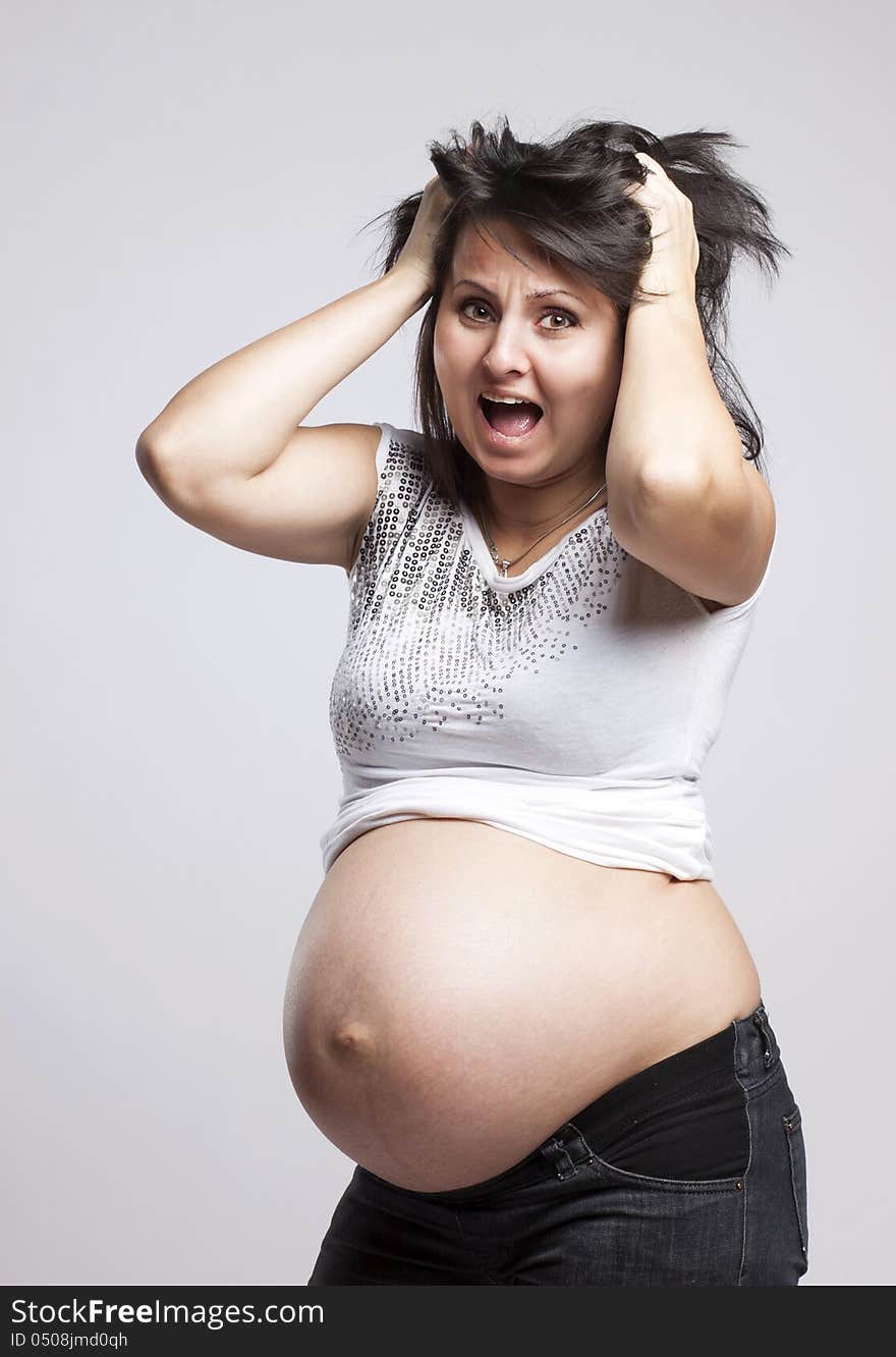 Scared pregnant woman holding her head