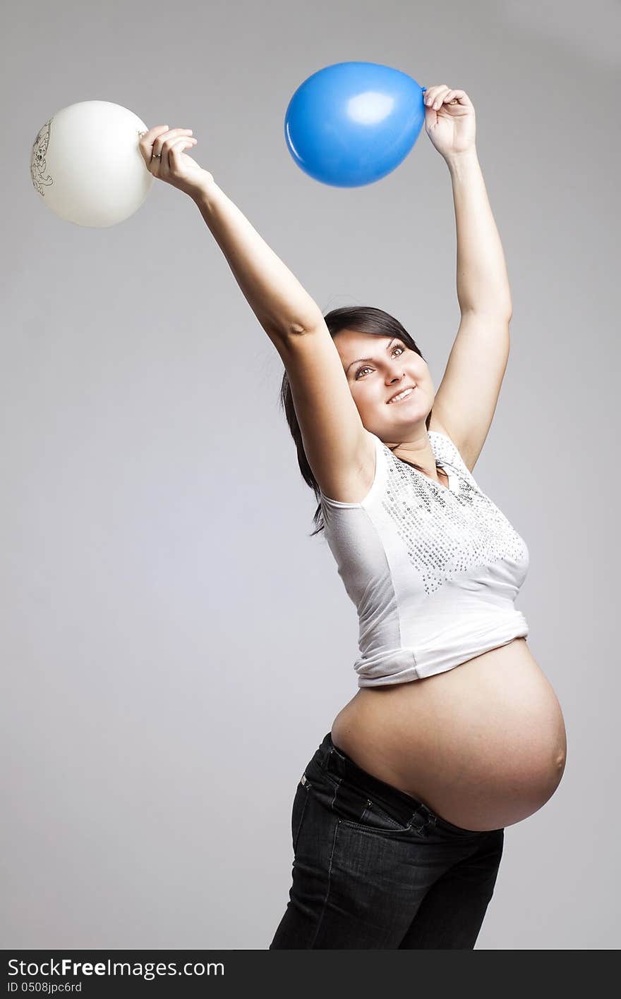 Beautiful pregnant woman playing with balloons