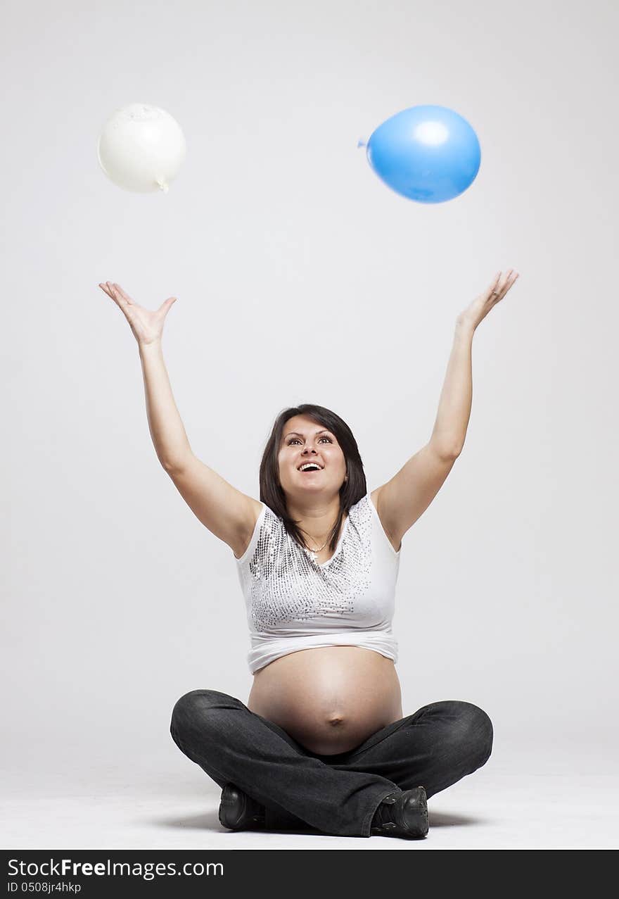 Beautiful pregnant woman playing with balloons