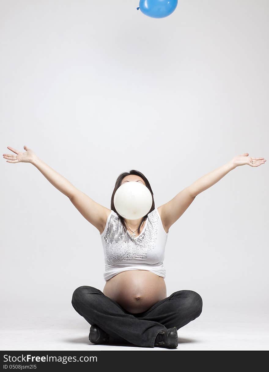 Beautiful pregnant woman playing with balloons