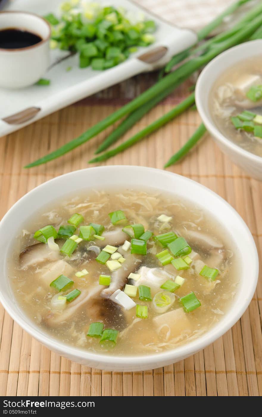 Chinese spicy soup with egg, shiitake mushrooms, tofu and green