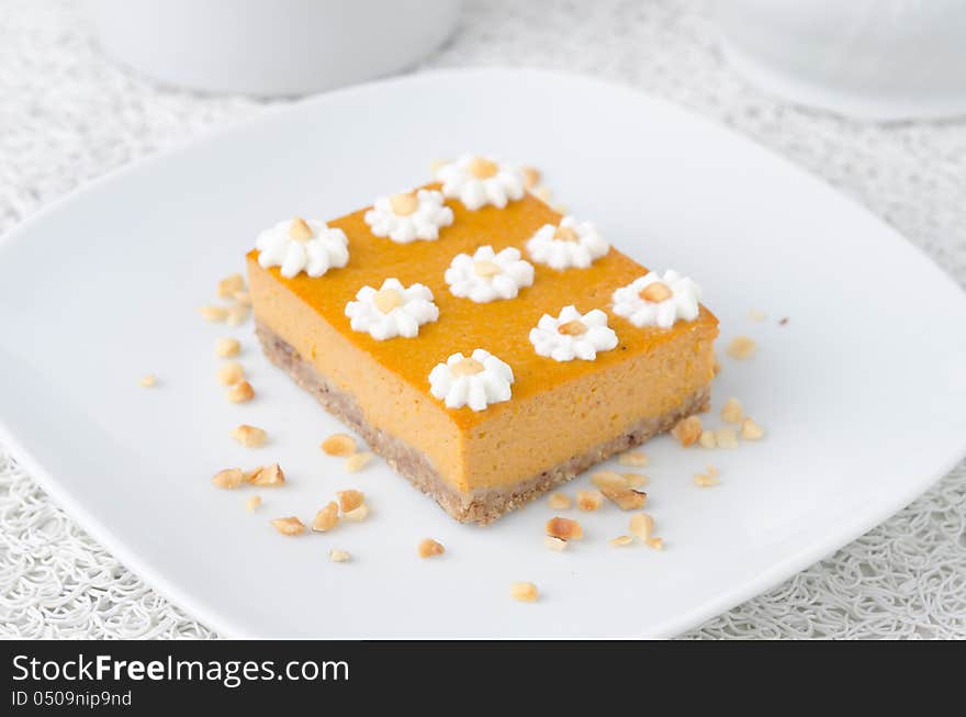 Pumpkin cake, decorated with flowers made of whipped cream and nuts