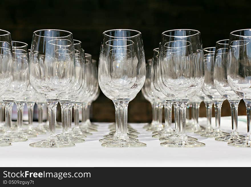 Empty wine glasses set up in a row on the table on black background