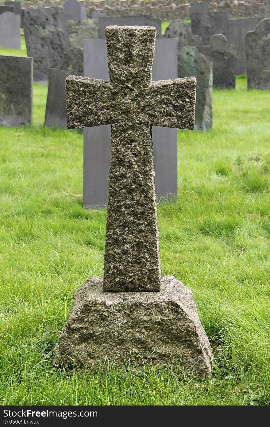 A Granite Stone Cross Standing in a Cemetery. A Granite Stone Cross Standing in a Cemetery.