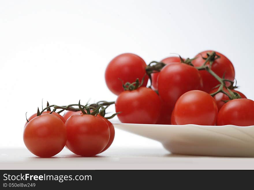 Tomatoes in a white plate on white background