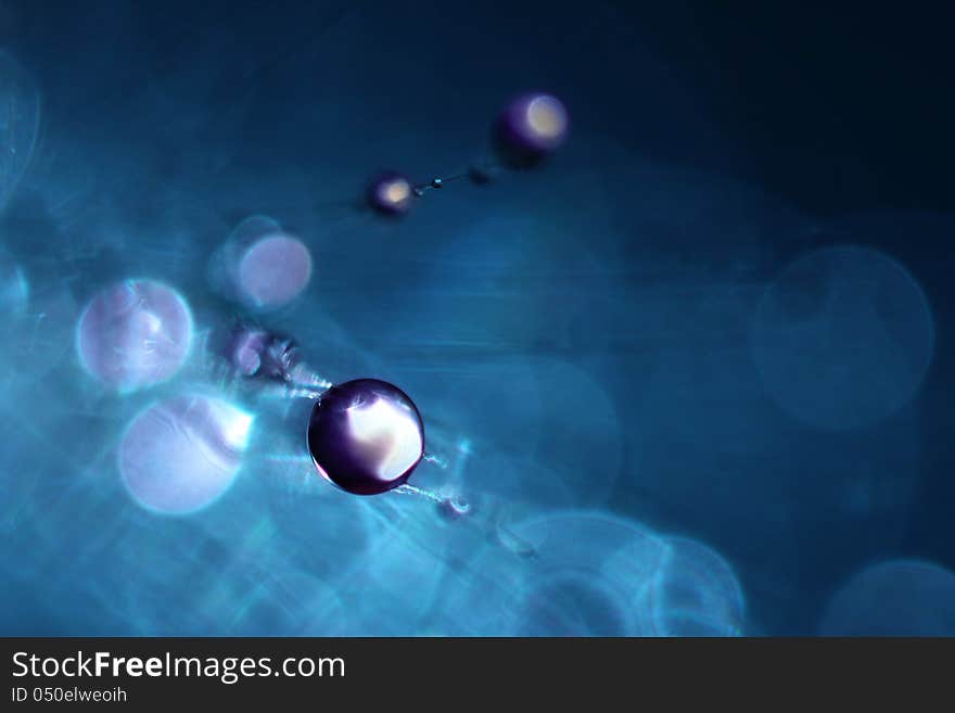 Drops of dew on dandelion closeup on blue background