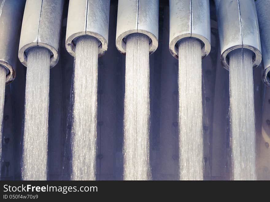 Powerful water jets falling from metallic pipes