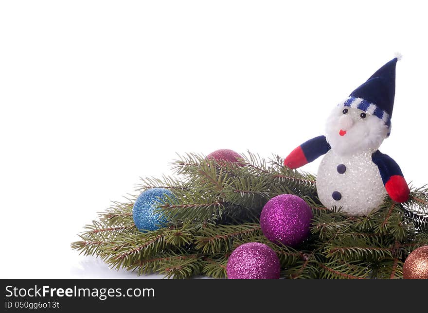 Colorful balls and snowman lying on spruce branches. background