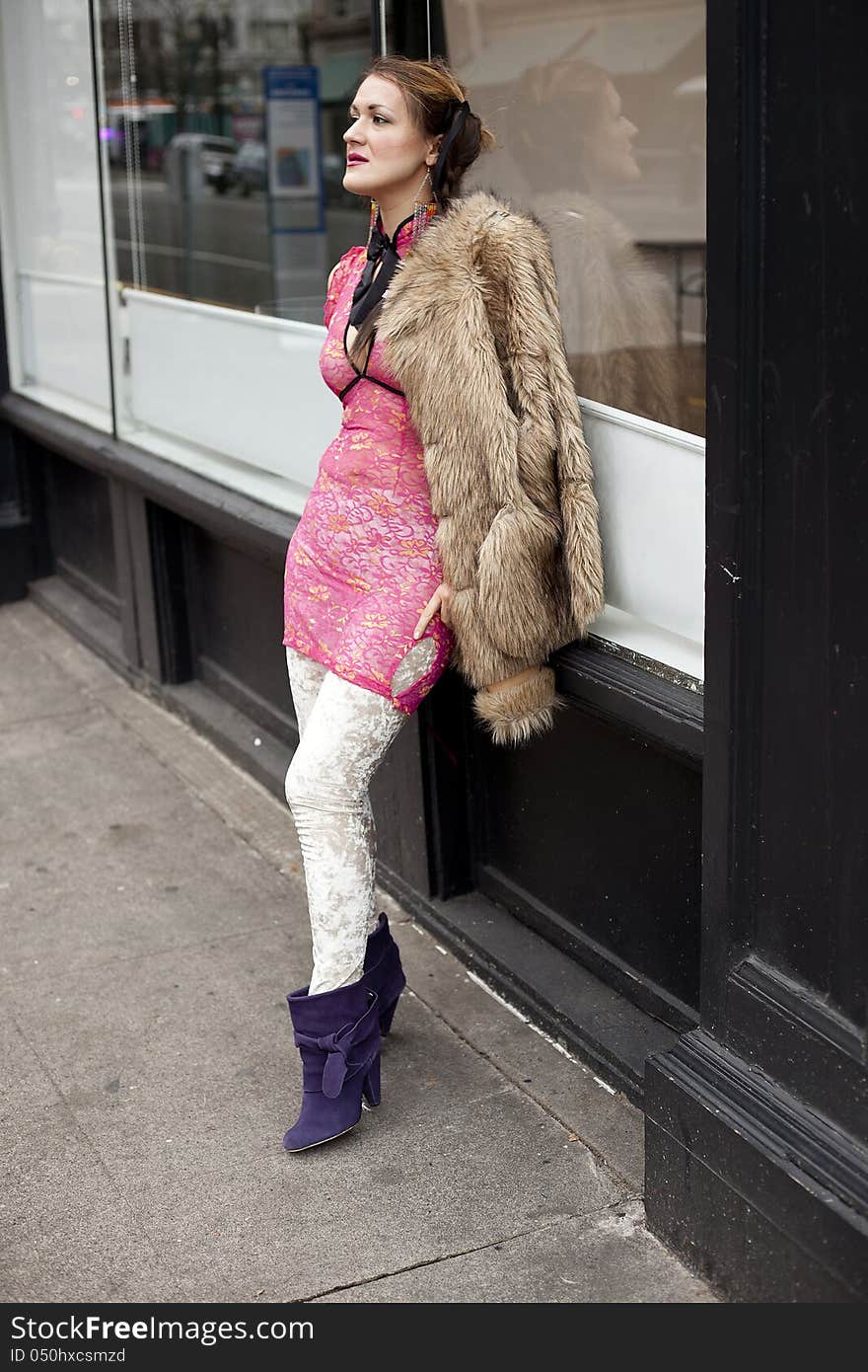 Young womanwith pink top and fur coat on the street. Young womanwith pink top and fur coat on the street.