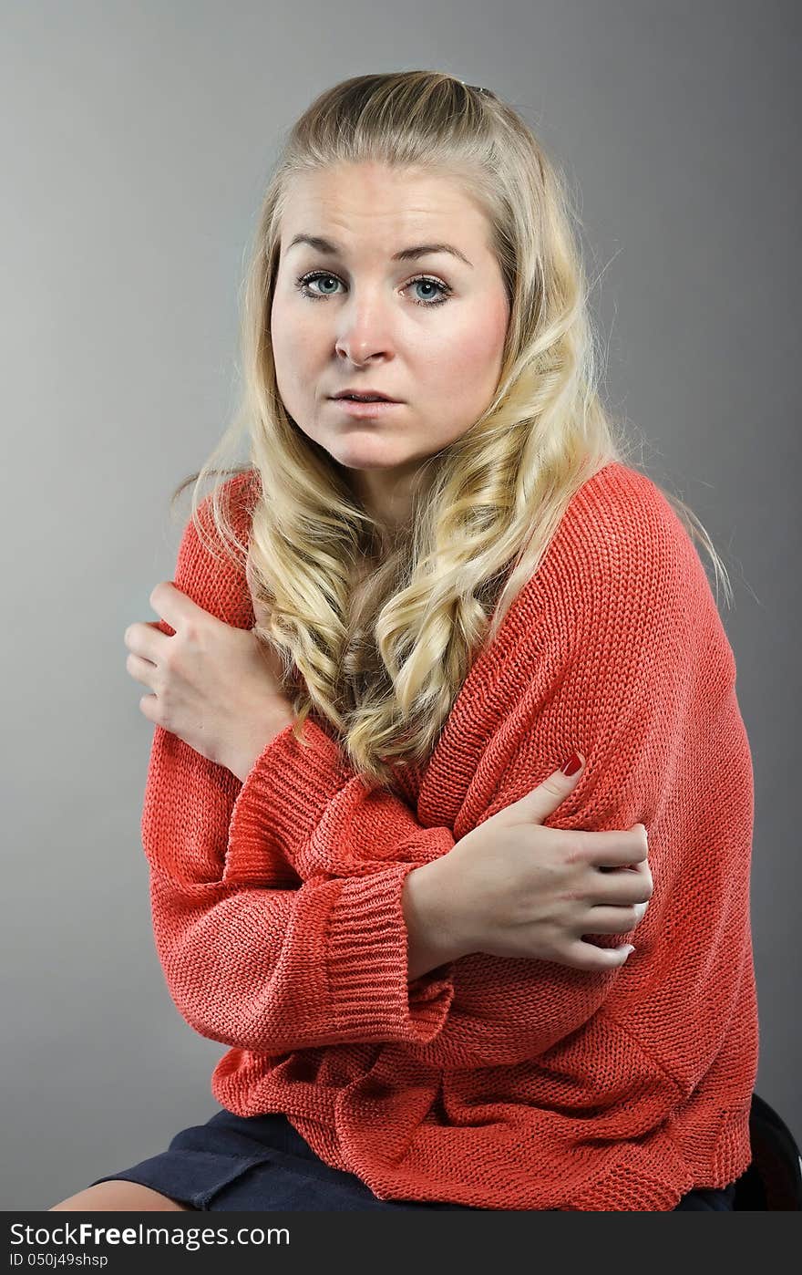 Studio picture of woman. Emotion is loneliness. Backgroud is gray.