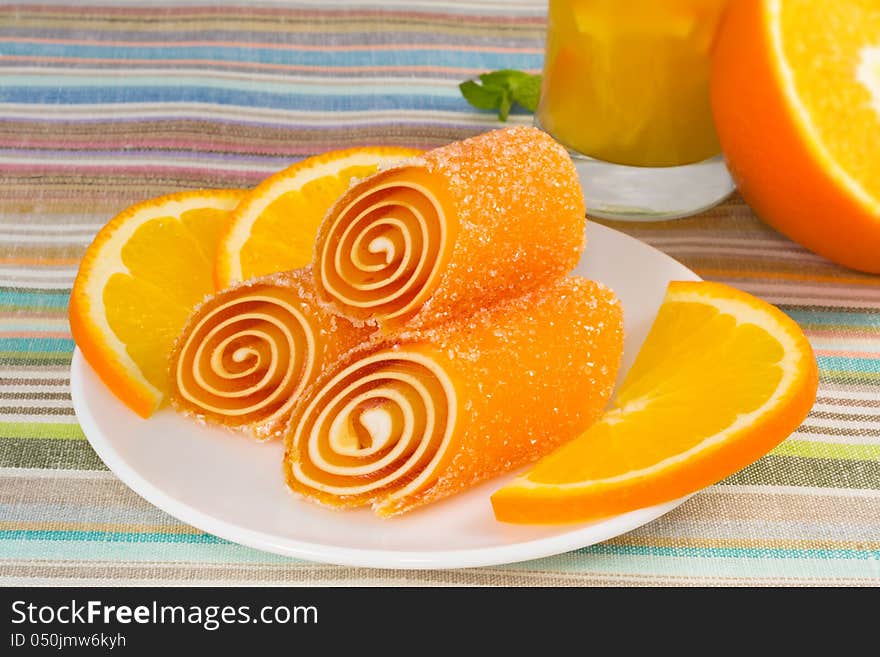 Candy fruit on a plate with orange, closeup