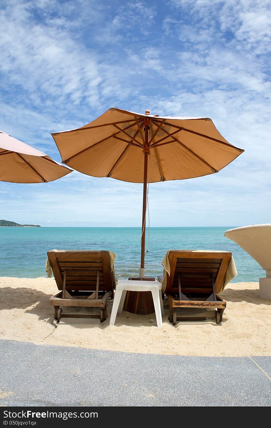 Beach umbrella and longues on the tropical sea